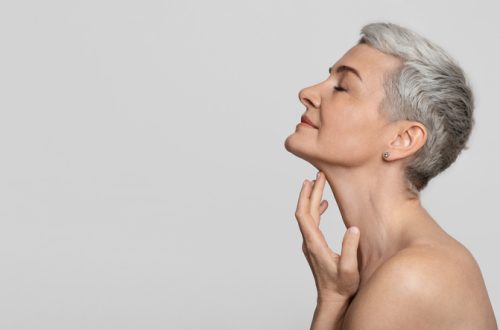Anti-Age Treatment. Beautiful middle-aged woman touching soft skin on her neck